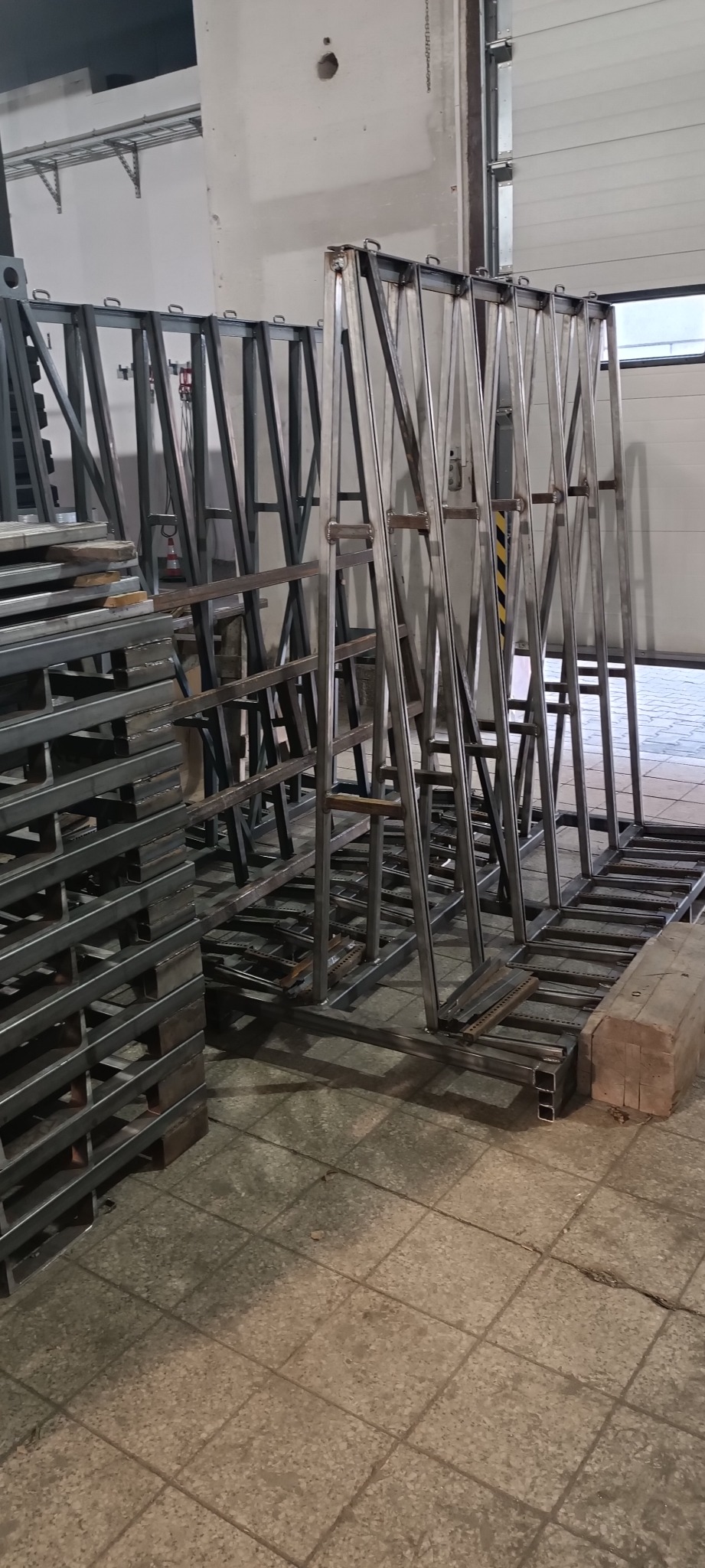 Konstrukcje stalowe, ramy i palety z profili stalowych, spawane, przygotowane do magazynowania lub transportu, widoczne ślady spawania.