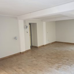 HIT HOUSE - Puste, odnowione wnętrze w Gdańsku z drewnopodobną podłogą, świeżo pomalowanymi ścianami i odsłoniętymi instalacjami elektrycznymi, gotowe do dalszych prac wykończeniowych.
