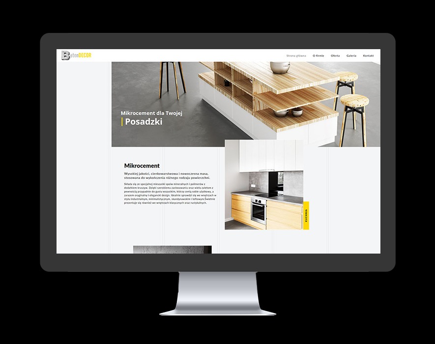 Ekran monitora wyświetlający stronę internetową firmy BetonDecor z aranżacjami wnętrz z wykorzystaniem mikrocementu, prezentującą minimalistyczną kuchnię z drewnianymi blatami i posadzką...