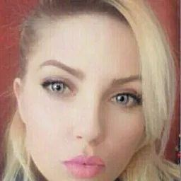 Portret kobiety z blond włosami i jasną karnacją, wykonany w zbliżeniu. Usta pomalowane na różowo, oczy niebieskie, tło czerwone. Zdjęcie portretowe.