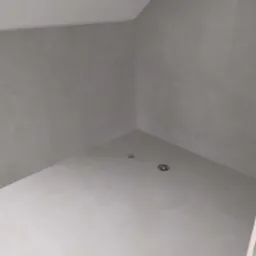 Wykończona kabina prysznicowa z szarymi płytkami na ścianach i białymi płytkami na podłodze, widoczne dwa odpływy liniowe.