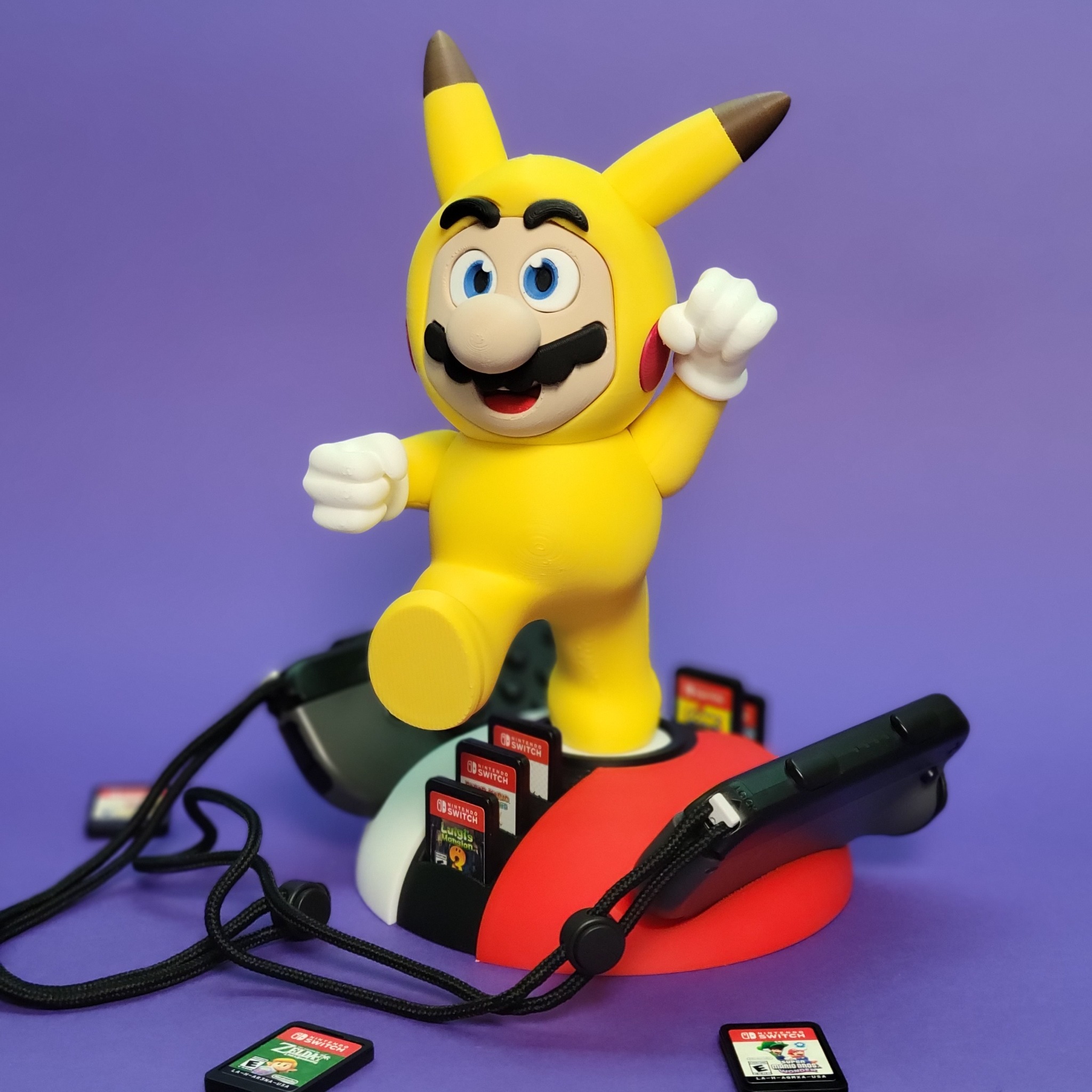Figurka Mario w stroju Pikachu, wyprodukowana metodami addytywnymi, umieszczona na podstawce z grami Nintendo Switch na fioletowym tle.