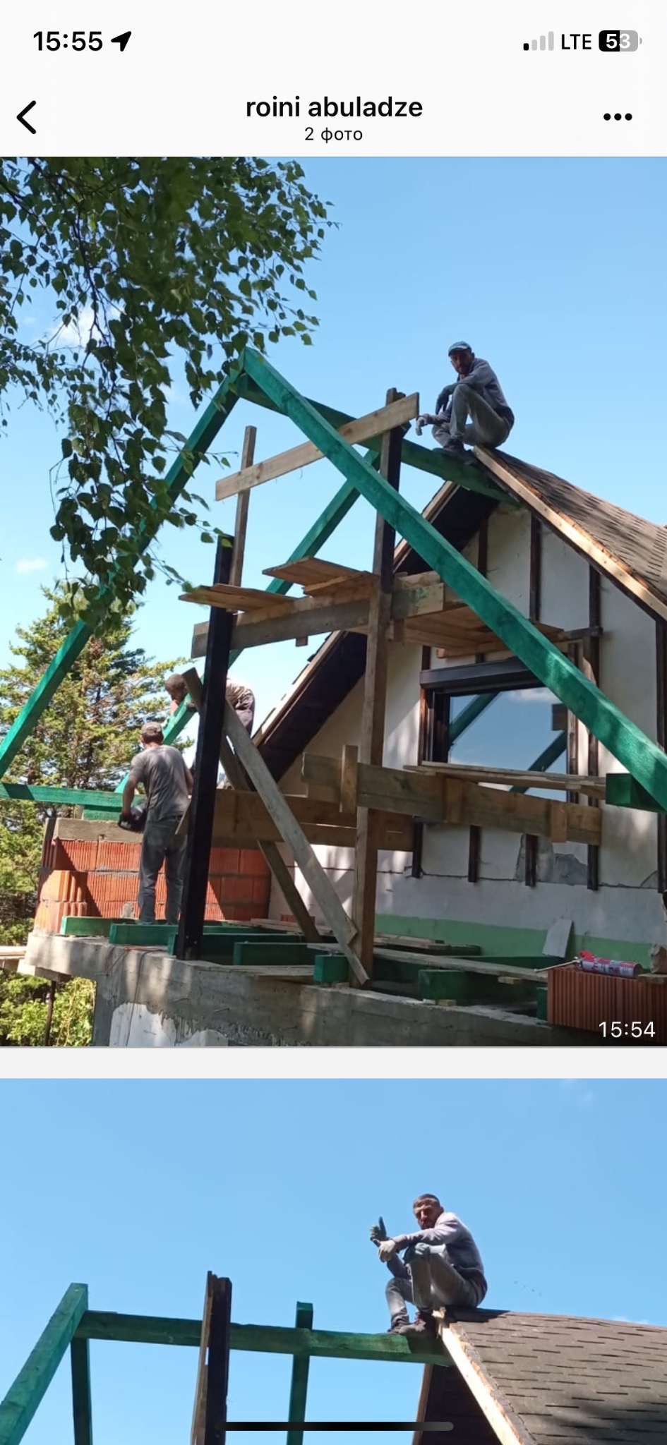 Budowa domu w toku: robotnicy na rusztowaniu montują drewnianą konstrukcję dachu, z widocznymi elementami izolacji i cegłami. Praca na wysokości.