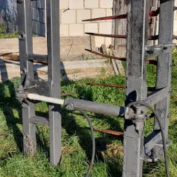 Metalowa konstrukcja po obr&oacute;bce w Siedlcach, z widocznymi śladami korozji i niedokładnościami malowania, ustawiona na trawie przed budynkiem z białej cegły.