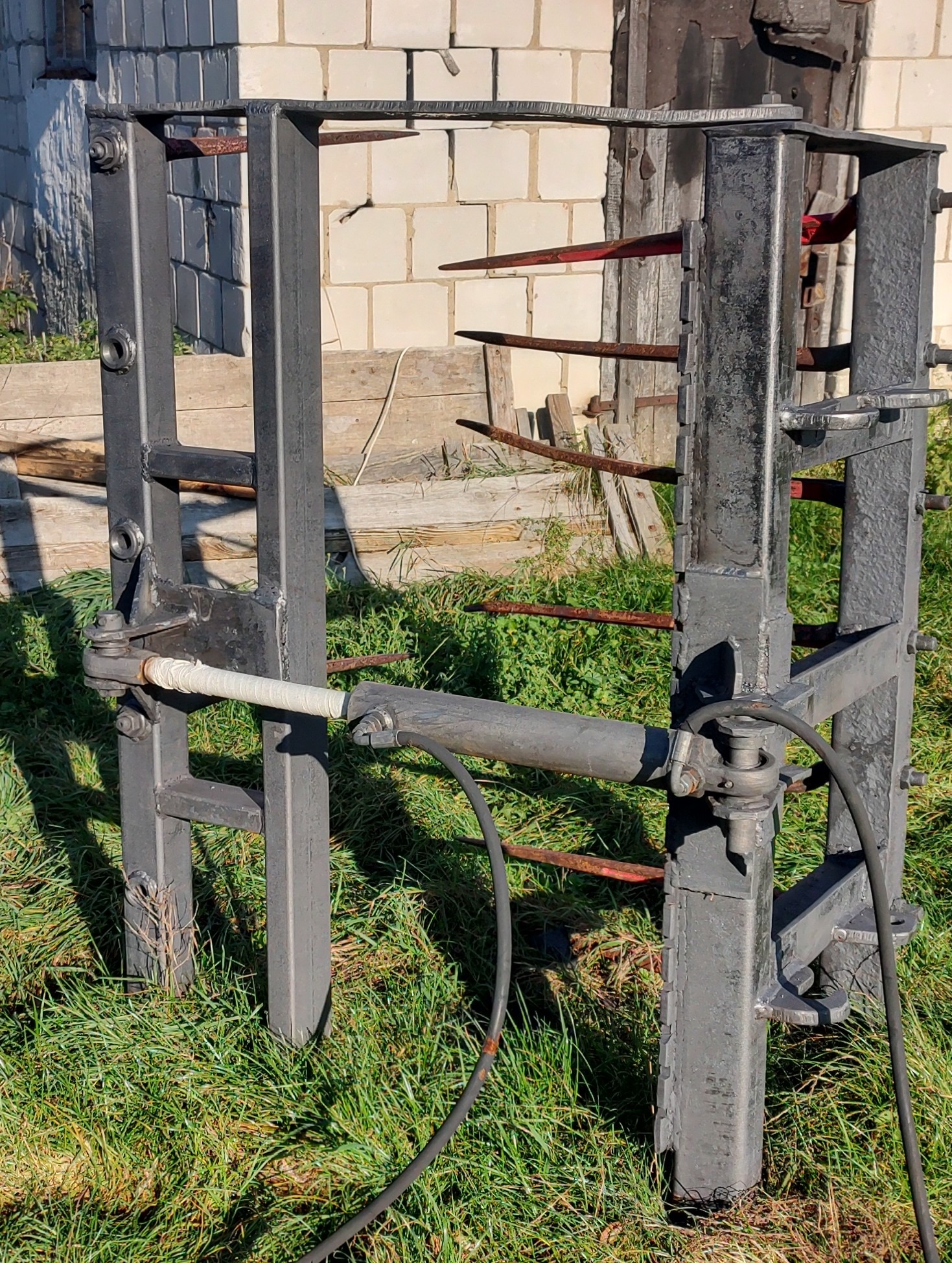 Metalowa konstrukcja po obróbce w Siedlcach, z widocznymi śladami korozji i niedokładnościami malowania, ustawiona na trawie przed budynkiem z białej cegły.