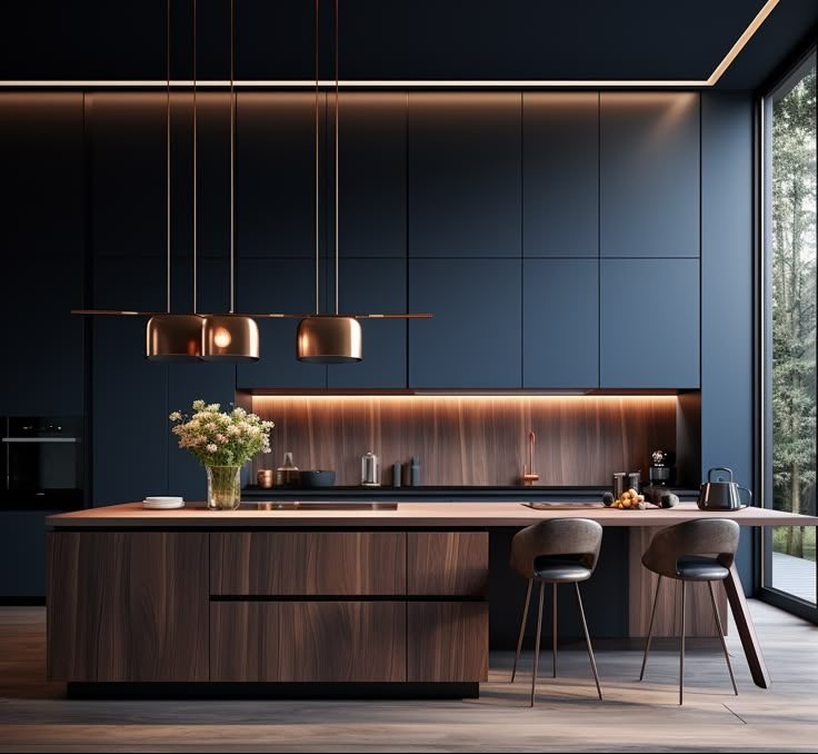 Nowoczesna kuchnia z wyspą i ciemnymi szafkami, oświetlona ciepłym światłem LED. Minimalistyczne lampy wiszące nad blatem. Widok na las przez okno.