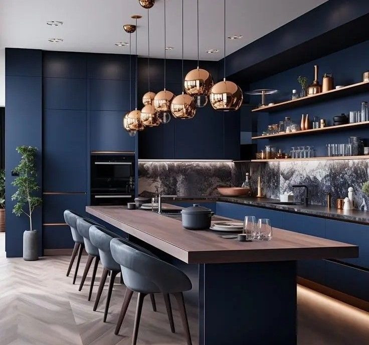 Elegancka, granatowa kuchnia z drewnianym blatem i złotymi lampami wiszącymi. Na blacie zastawa stołowa i garnek. Na półkach dekoracje. Nowoczesny design.