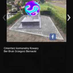 Granitowy nagrobek na cmentarzu z wybrukowanym otoczeniem z kostki, widok z góry, krzewy w tle.