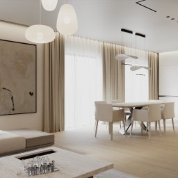 Kaolin Interiors Karolina Grzywa - Jasne wnętrze: sofa, stół z krzesłami, abstrakcyjny obraz na ścianie, minimalistyczne lampy wiszące. Nowoczesny design z drewnianymi akcentami i dużymi oknami.