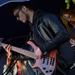 Coffee Cup - Muzycy grający na basie i gitarze elektrycznej pod namiotem, z widocznymi mikrofonami i fragmentami instrumentów innych muzyków.