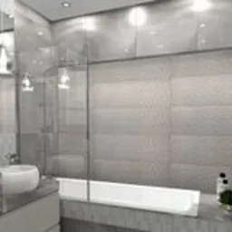 Nowoczesna łazienka z szarymi płytkami, przeszklonym prysznicem nad wanną i minimalistyczną umywalką. Delikatne oświetlenie punktowe i dekoracyjne detale dodają elegancji.