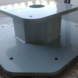 Ekoauto - Szara, metalowa konstrukcja wspornikowa z widocznymi spawami i otworami montażowymi, leżąca na folii ochronnej.