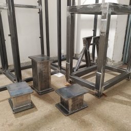 Ekoauto - Surowe, spawane konstrukcje stalowe: rama, stoliki i podpory, w warsztacie, przed malowaniem lub wykończeniem.