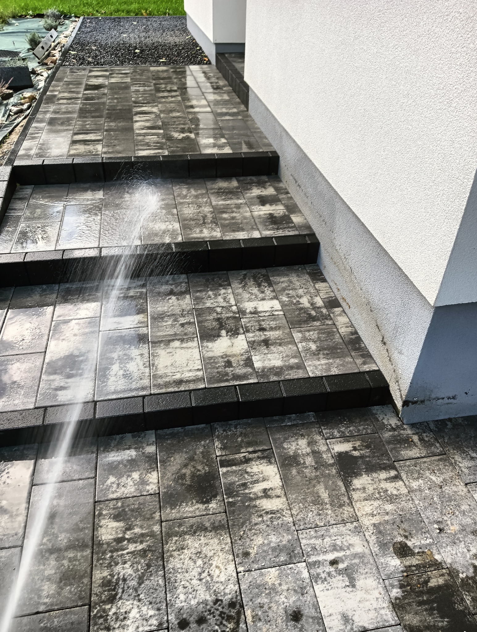 Schody z kostki brukowej w kolorze szaro-czarnym, czyszczone strumieniem wody pod ciśnieniem, widok z góry.