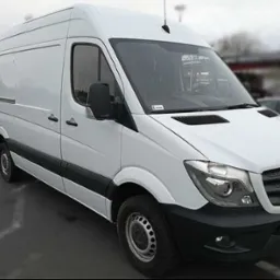 Biały samochód dostawczy marki Mercedes-Benz Sprinter zaparkowany na parkingu, widok z przodu i boku.