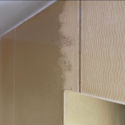 Clean Time - Fragment ściany z beżowymi, wzorzystymi płytkami, częściowo pokrytej warstwą brudu i osadu, ukazujący efekt przed czyszczeniem.