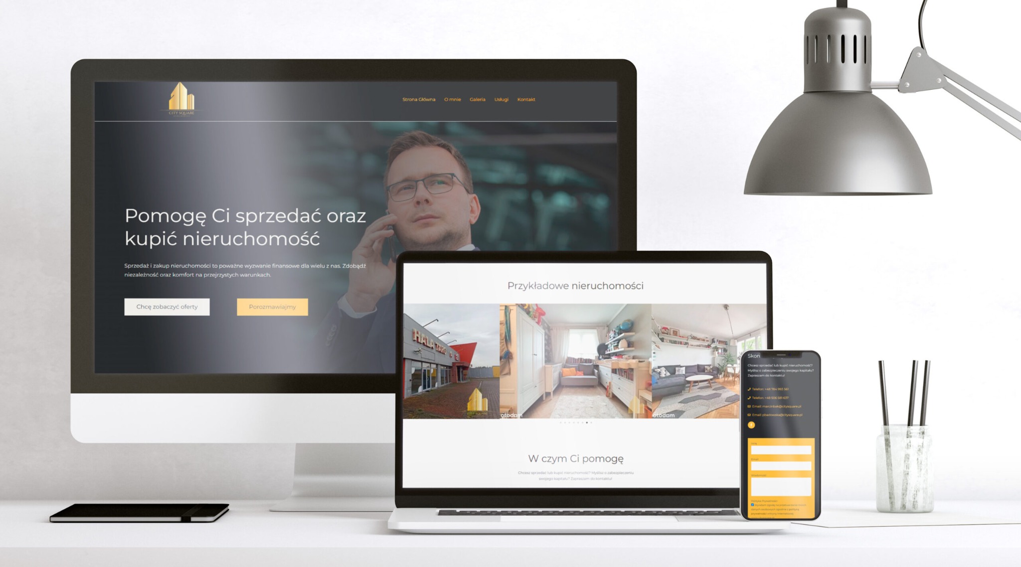 Responsywna strona internetowa biura nieruchomości wyświetlana na monitorze, laptopie i smartfonie, prezentująca przykładowe oferty i dane kontaktowe, oświetlona lampką biurkową.