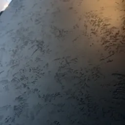 Szpachlowana ściana w Gorlicach z wyraźną fakturą w odcieniach szarości, oświetlona ciepłym światłem z góry, tworząca efekt trójwymiarowości.