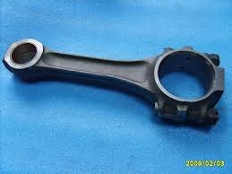 Korbowód do kompresora Airpol N 30, dostępny we Włocławku, na tle niebieskiej tkaniny. Część zamienna do naprawy.