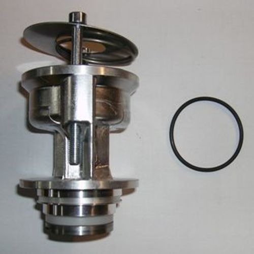 Metalowy zawór sprężarki z elementami uszczelniającymi, w tym czarnym o-ringiem, na jasnym tle.