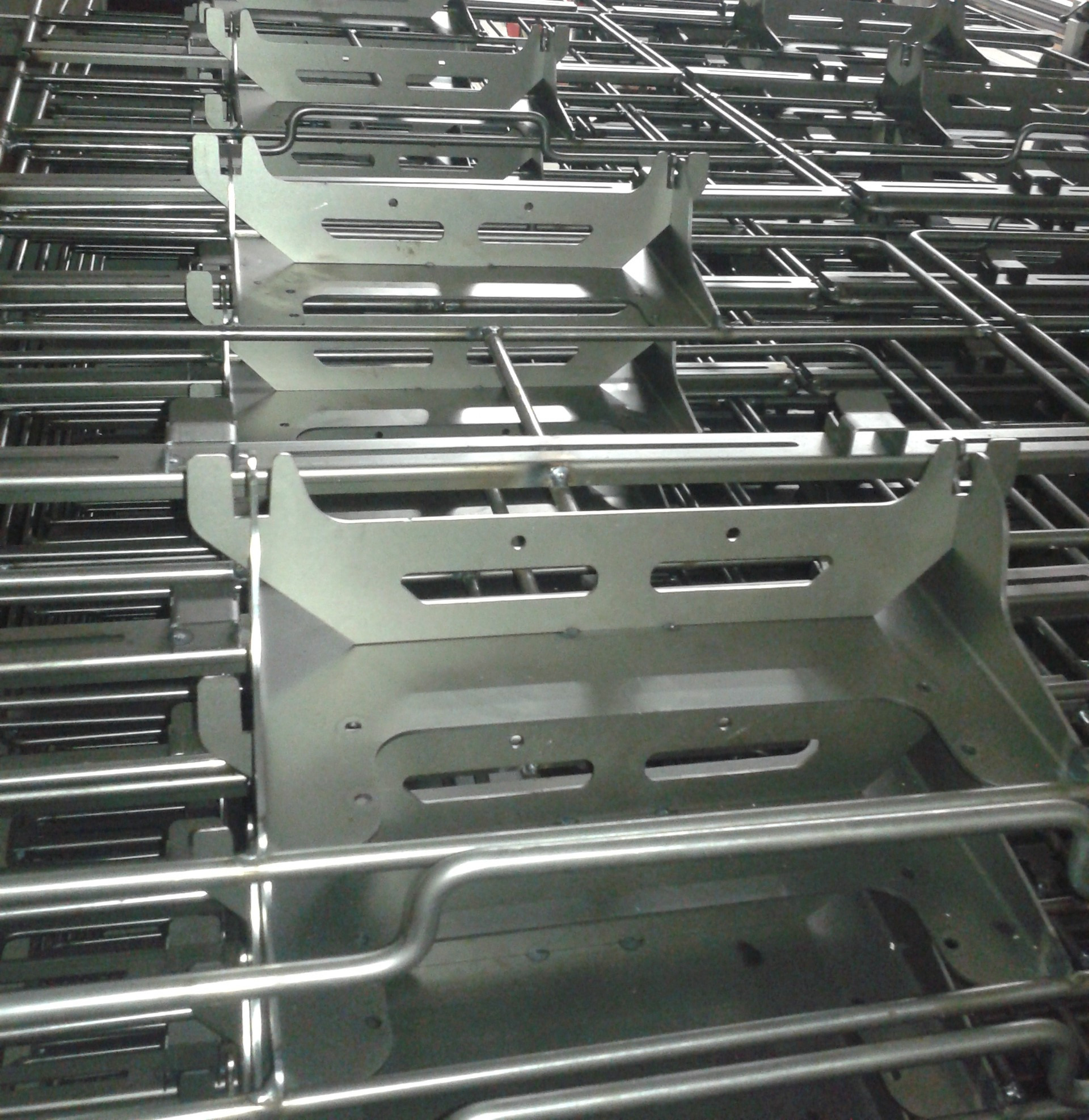 Metalowe konstrukcje spawane z rur i blach, ułożone jedna na drugiej, widoczne ślady spawania i obróbki.