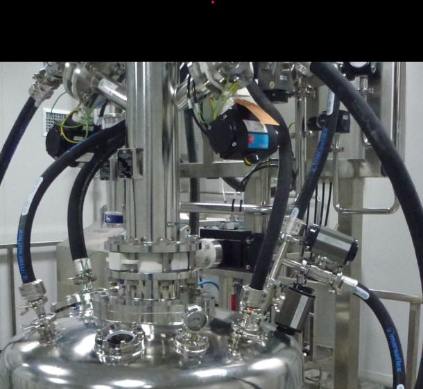 Zbliżenie na skomplikowaną instalację przemysłową ze stali nierdzewnej z licznymi rurami, zaworami i czujnikami, prawdopodobnie część większego systemu produkcyjnego.