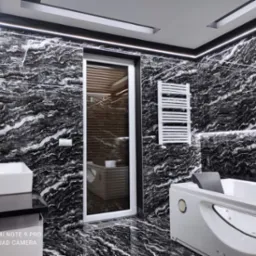 Elegancka łazienka z czarno-białymi marmurkowymi płytkami, oświetleniem LED pod sufitem, białą wanną z hydromasażem i grzejnikiem drabinkowym.