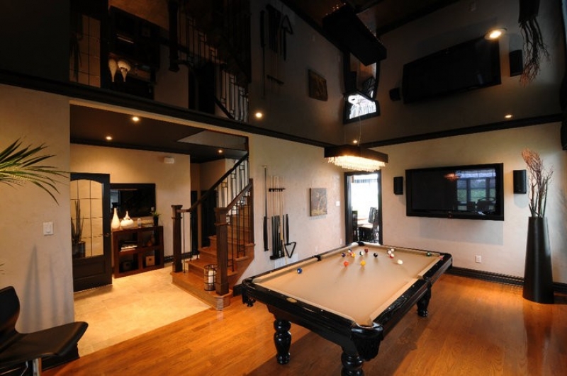 Przestronny pokój z bilardem, schodami na antresolę i czarnym, lakierowanym sufitem z wbudowanymi reflektorami punktowymi.