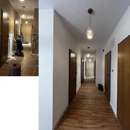 GENX SERVICES - Korytarz w trakcie malowania: ściany pomalowane na biało, drewniane drzwi z niebieską taśmą malarską, podłoga w panelach imitujących drewno, ozdobne lampy sufitowe, widoczny pracownik w trakcie...