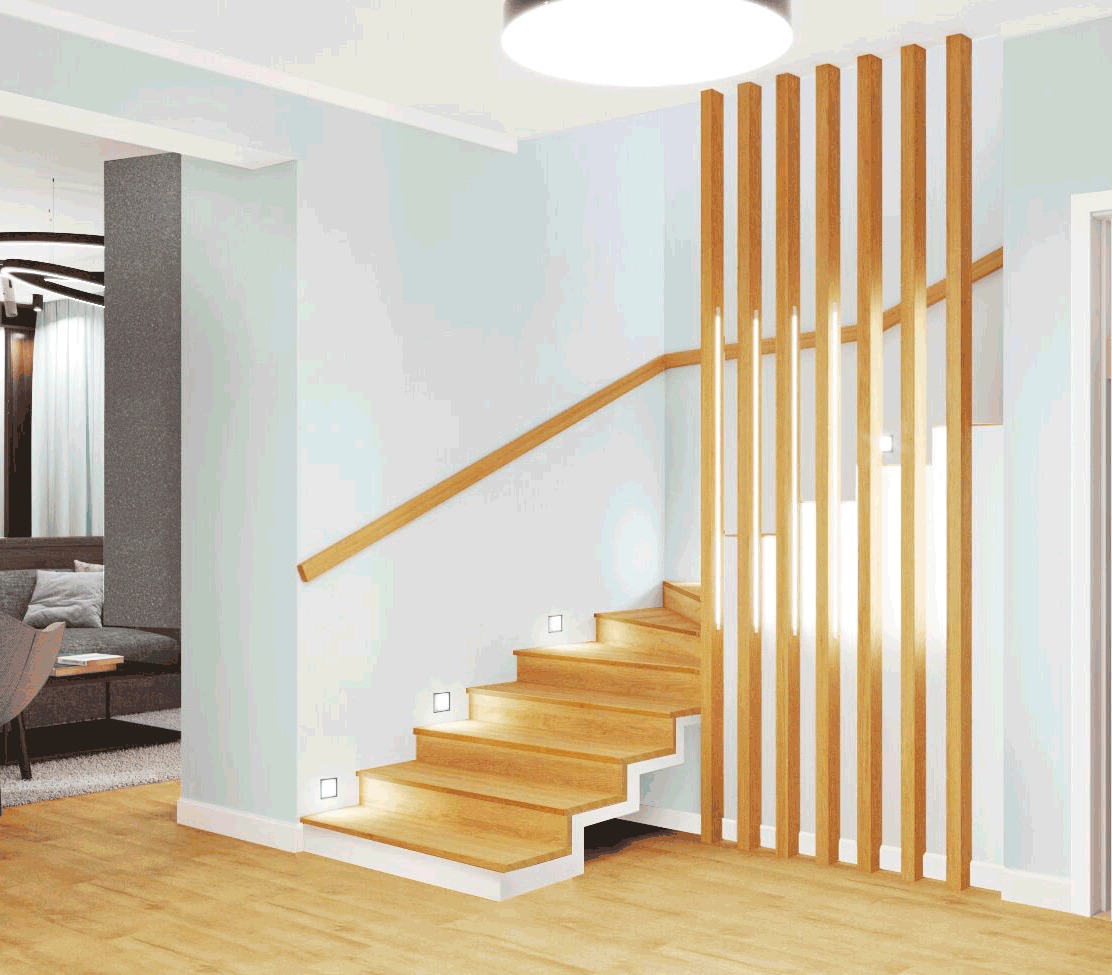 Drewniane schody z podświetleniem LED w stopniach i pionowymi drewnianymi lamelami pełniącymi funkcję barierki, widok z dołu w jasnym wnętrzu.