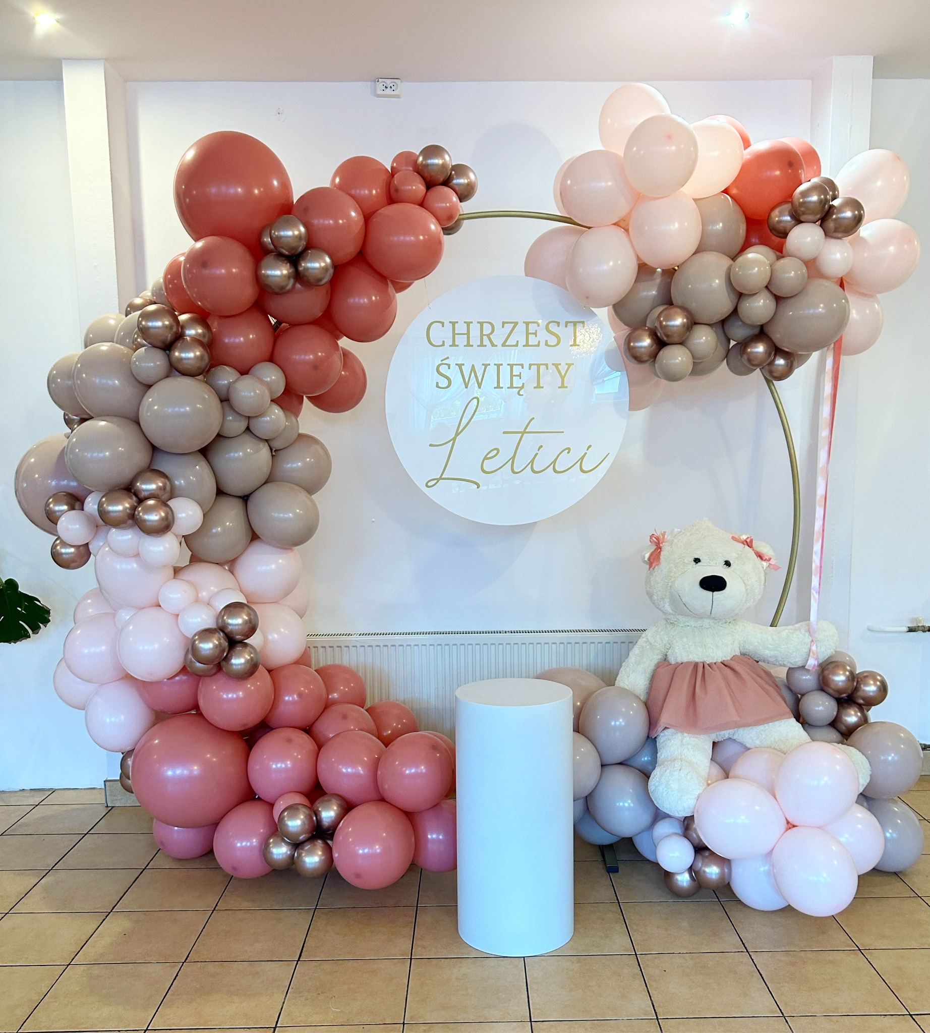 Dekoracja balonowa w odcieniach różu i beżu na Chrzest Święty z pluszowym misiem na białym postumencie