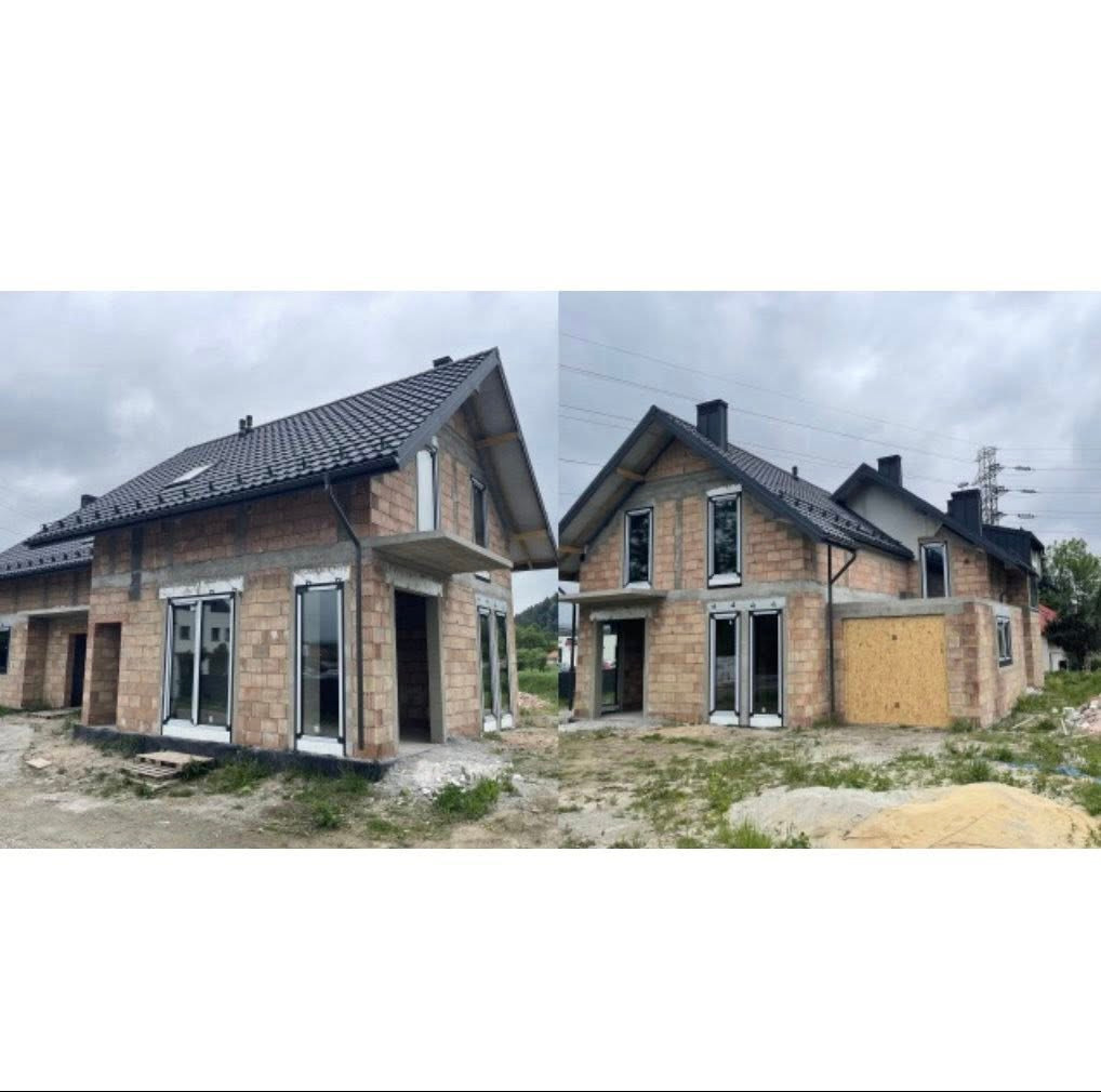 Dwa surowe domy w stanie deweloperskim, z czarną dachówką i białymi ramami okiennymi, uchwycone pod pochmurnym niebem. Widoczne elementy konstrukcyjne i otoczenie budowy.