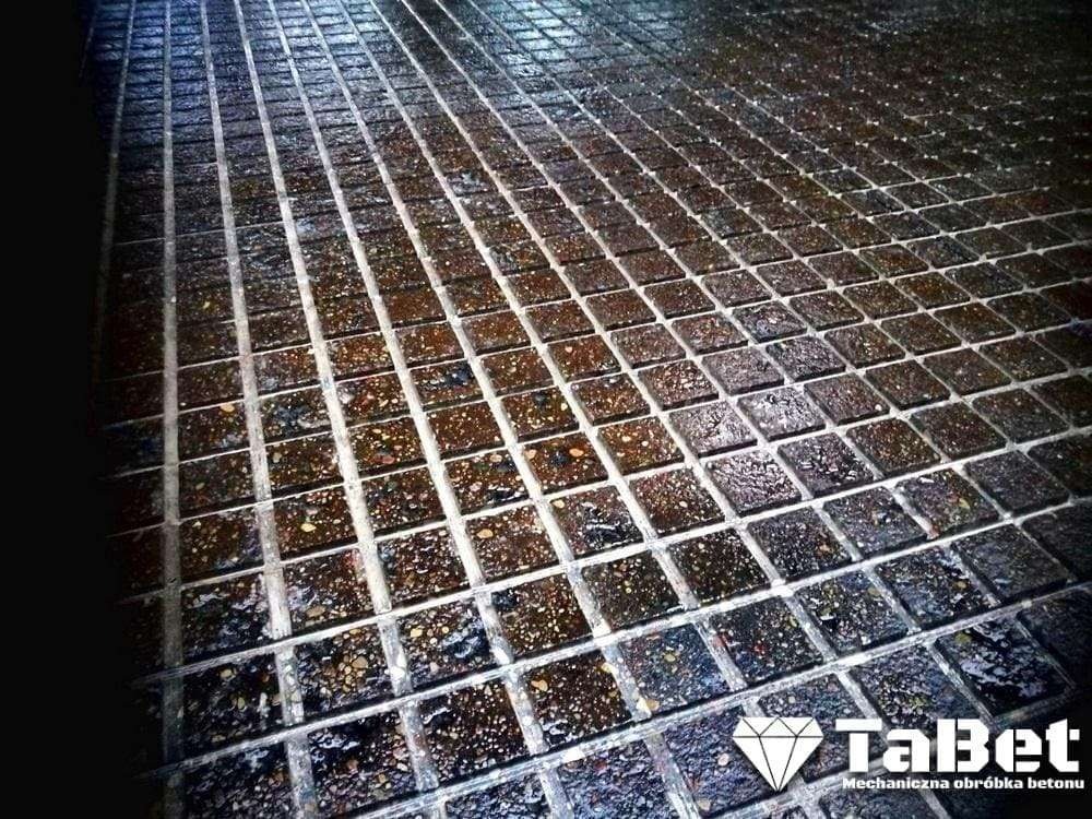 Krzyżowo nacinana, mokra posadzka betonowa z widocznym logo firmy TabBet, mechaniczna obróbka betonu.