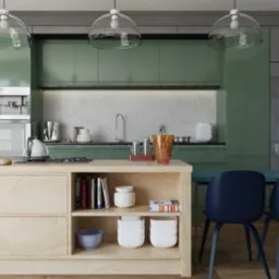 Nowoczesna kuchnia z zielonymi szafkami, drewnianą wyspą z książkami i niebieskimi krzesłami, oświetlona trzema szklanymi lampami wiszącymi.