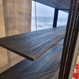 FTB SPÓŁKA Z OGRANICZONĄ ODPOWIEDZIALNOŚCIĄ - Ciemne żaluzje bambusowe 50mm z widokiem na zimowy krajobraz za oknem. Detal sznurków sterujących i faktury drewna. Ujęcie z dołu, podkreślające głębię perspektywy.