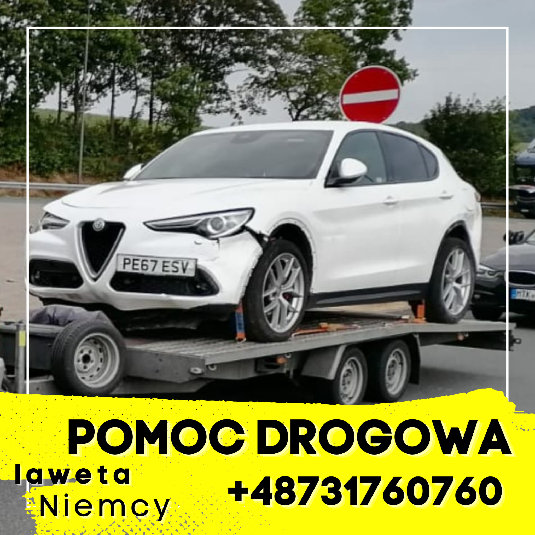 Uszkodzony, biały samochód osobowy marki Alfa Romeo na lawecie z widocznym znakiem zakazu w tle.