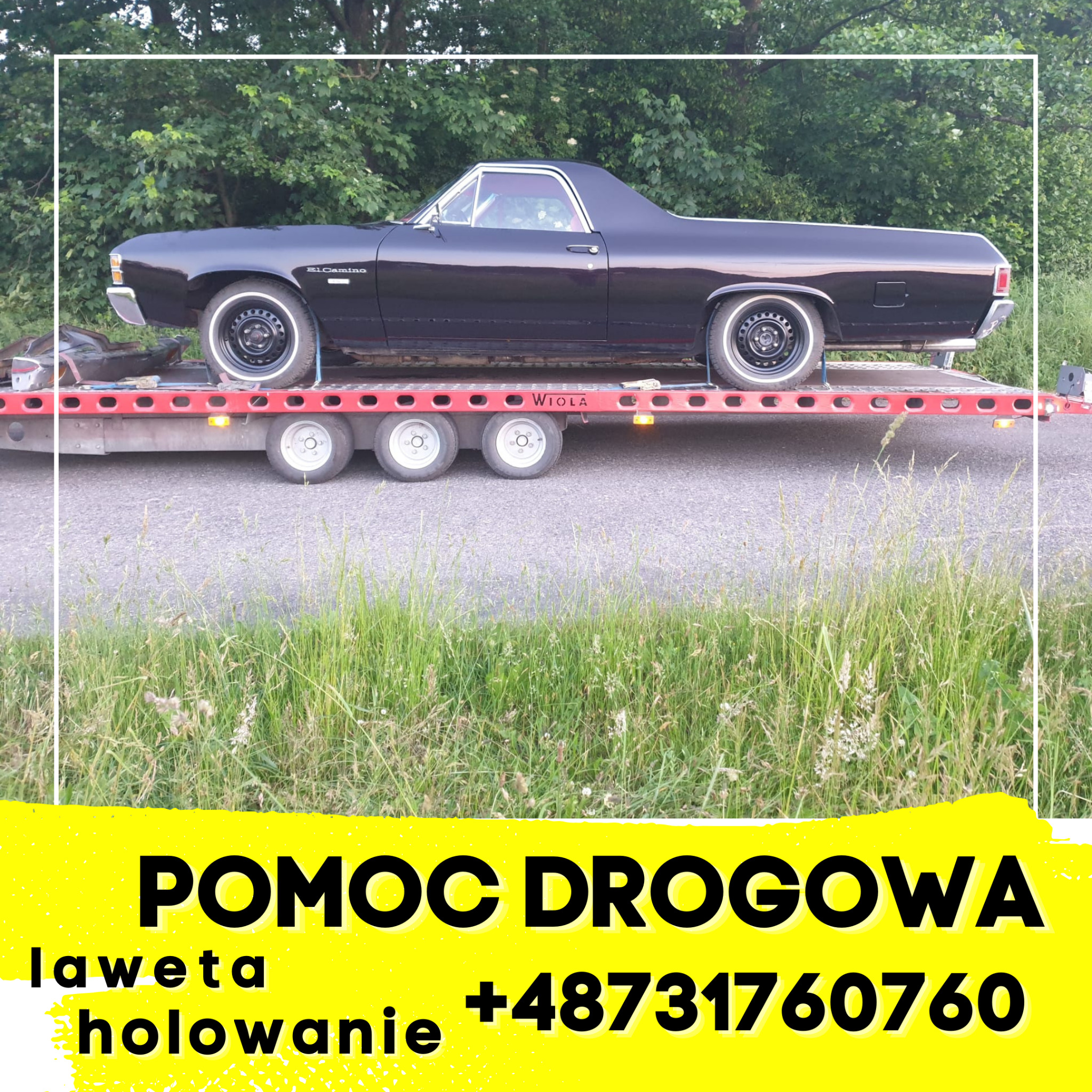 Czarny samochód El Camino na czerwonej lawecie marki Wiola, widok z boku na tle zieleni, z żółtym banerem 'Pomoc Drogowa' i numerem telefonu.