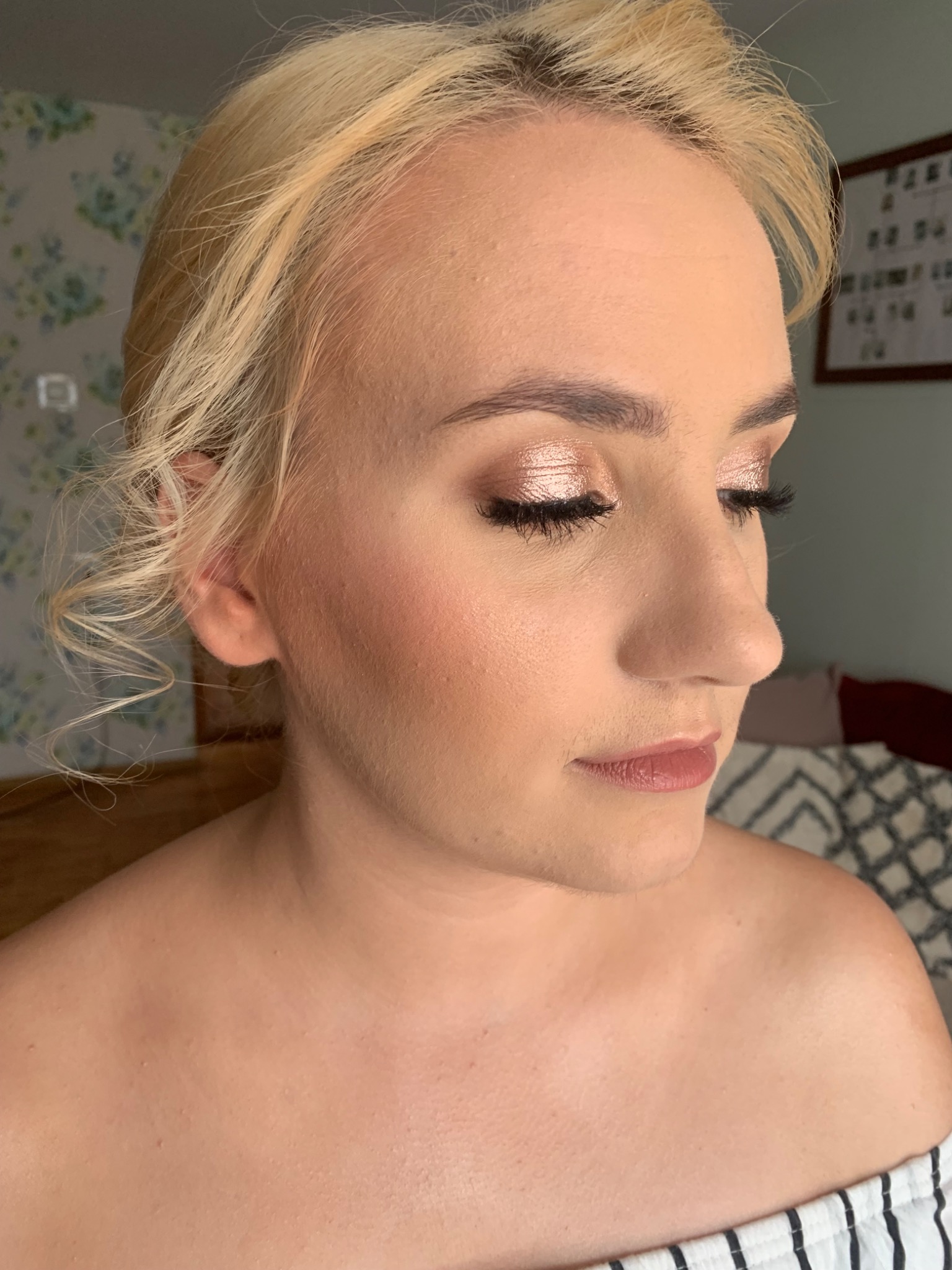 Portret kobiety z delikatnym makijażem w odcieniach brązu i złota, wykonanym w Konopiskach, z widocznymi sztucznymi rzęsami i podkreślonymi kośćmi policzkowymi.