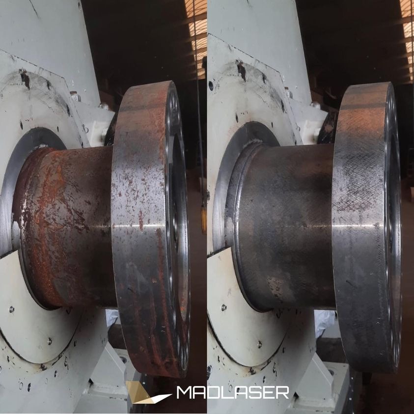 Porównanie stanu metalowego elementu przed i po czyszczeniu laserowym, widoczna rdza usunięta z lewej strony, gładka powierzchnia po prawej, element zamontowany w maszynie.
