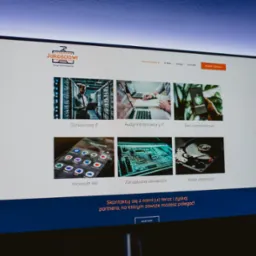 Ekran monitora wyświetlający stronę internetową firmy Jakosciowi z ofertą usług informatycznych, w tym Outsourcing IT, Audyt Infrastruktury IT, Sieci komputerowe, Microsoft 365, Zarządzanie...