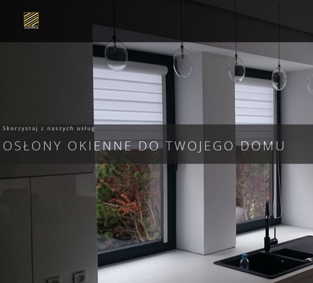 Nowoczesna kuchnia z roletami dzień noc w oknach, minimalistyczny design, wiszące lampy nad blatem, widok na zieleń za oknem.