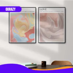 Dwa abstrakcyjne obrazy w czarnych ramkach wiszące na ścianie nad biurkiem z książkami i kubkiem, z widocznym cieniem.