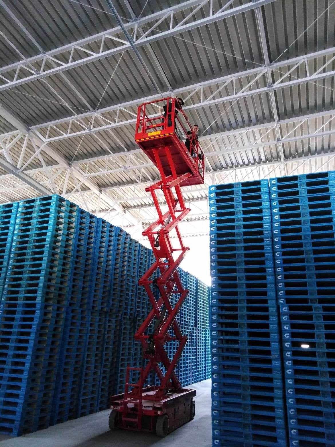 Montaż oświetlenia na hali magazynowej, prace na wysokościach