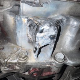 Yurii Ospishchev - Perfect Welding - Szczegółowe ujęcie spawu na metalowej konstrukcji, widoczne ślady obróbki i mocowania śrubowe. Metal ma szary odcień z widocznymi śladami użytkowania.