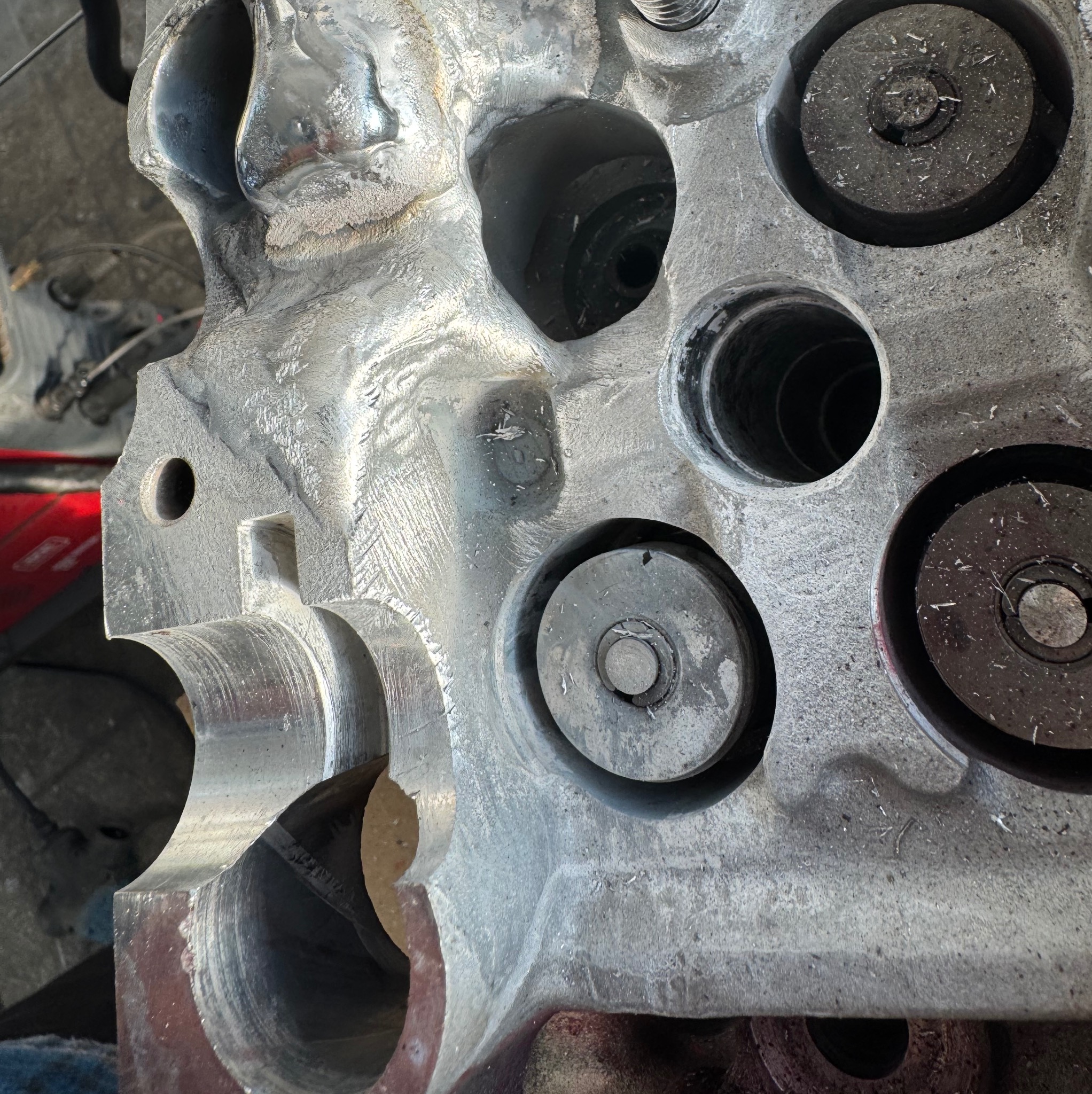 Szlifowany blok silnika z widocznymi otworami i śladami obróbki, ukazujący precyzję wykonania i dbałość o detale w procesie obróbki metalu.