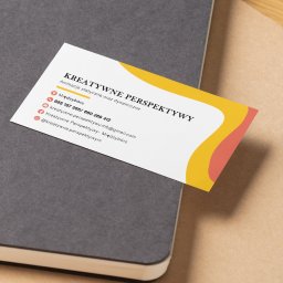 ZborowskaArt - Wizytówka z grafiką w kolorach żółtym i koralowym na szarym notatniku. Minimalistyczny design z danymi kontaktowymi i nazwą firmy: Kreatywne Perspektywy.