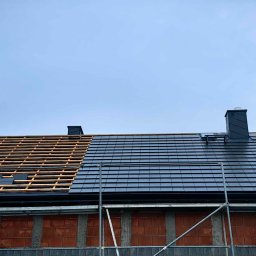 Mateusz Szkopiak Usługi Budowlane - Częściowo pokryty dach domu jednorodzinnego z czarną dachówką, widoczne rusztowania i komin, część dachu z odkrytą konstrukcją drewnianą.