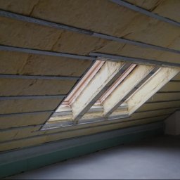 Mateusz Szkopiak Usługi Budowlane - Poddasze z ociepleniem z wełny mineralnej, widoczne metalowe profile i okno dachowe w trakcie montażu.