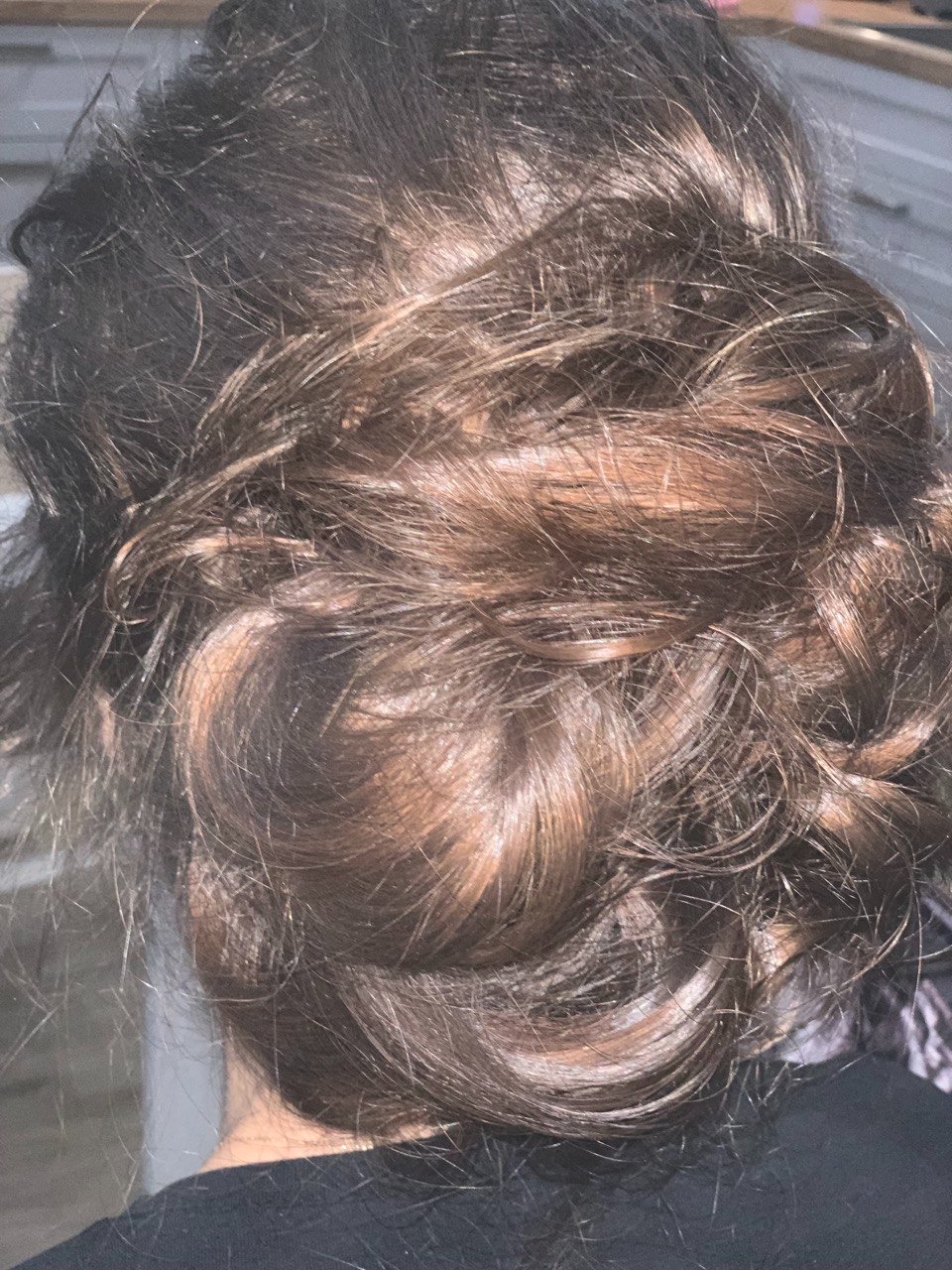 Upięcie włosów w kok z warkoczem, widok z tyłu, ciemne włosy z refleksami.