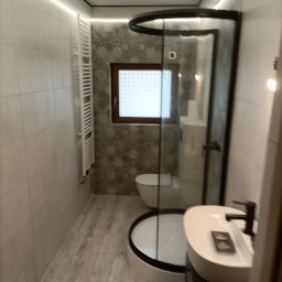 Daw-bau - Nowoczesna łazienka z kabiną prysznicową typu walk-in, umywalką nablatową i grzejnikiem drabinkowym. Płytki w odcieniach szarości i beżu, oświetlenie LED.